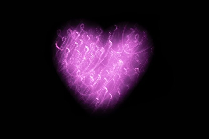 Herz aus lila Licht vor schwarzem Hintergrung